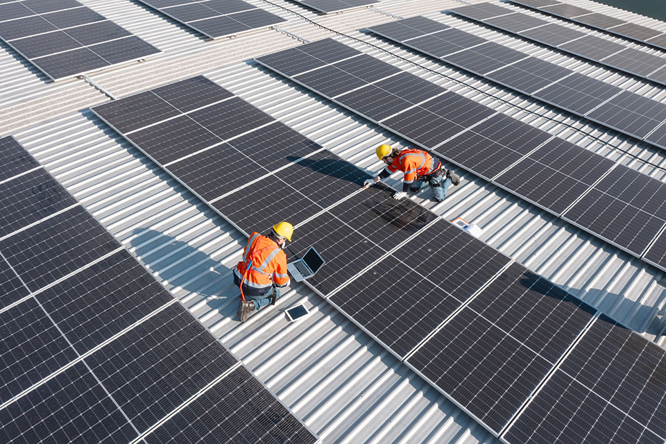 Ingenieure prüfen Installation von Solarzellen auf Fabrikdach (Foto: AU USAnakul/Shutterstock.com)