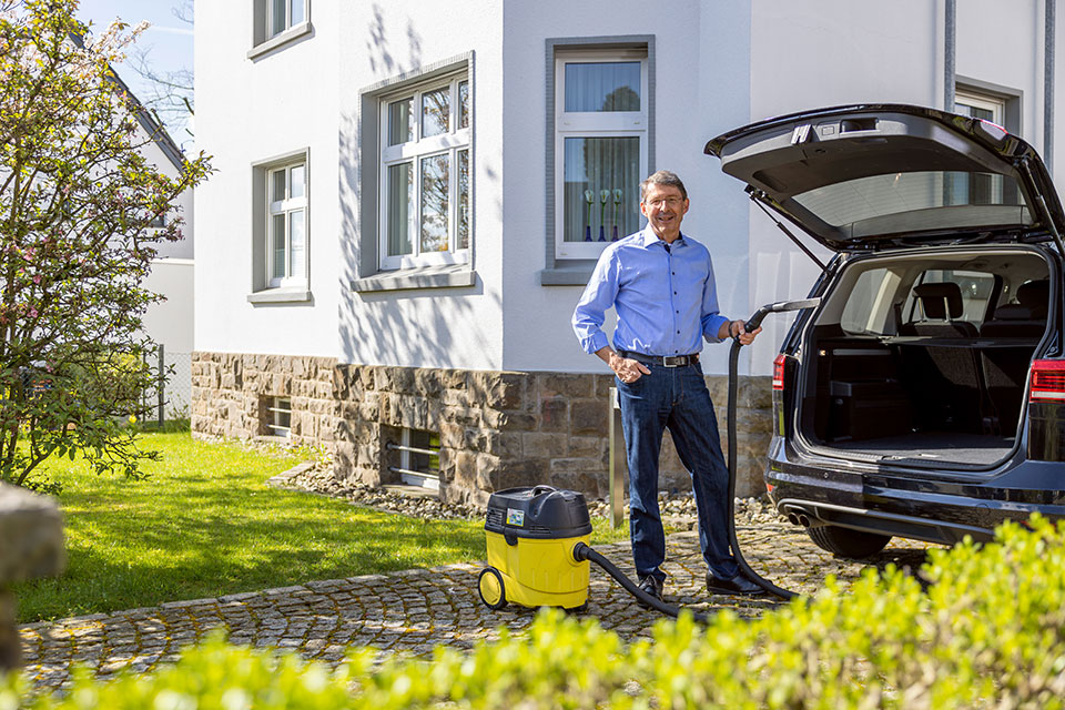 Mann mit Sauger vor einem Auto. Foto: Sascha Kreklau