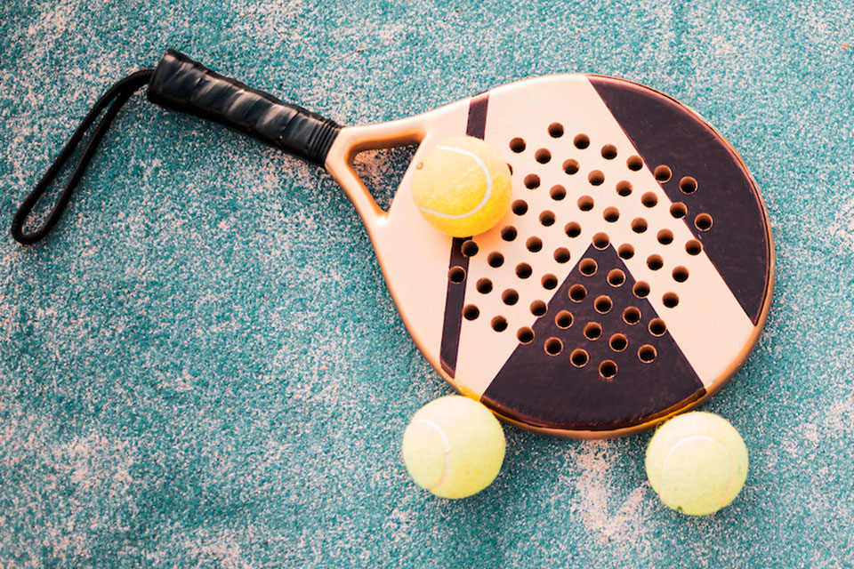 Ein Paddel-Tennisschläger, der mit 3 Bällen auf dem Boden ruht (Bildnachweis: Jesus Rodriguez/istockphoto.com)