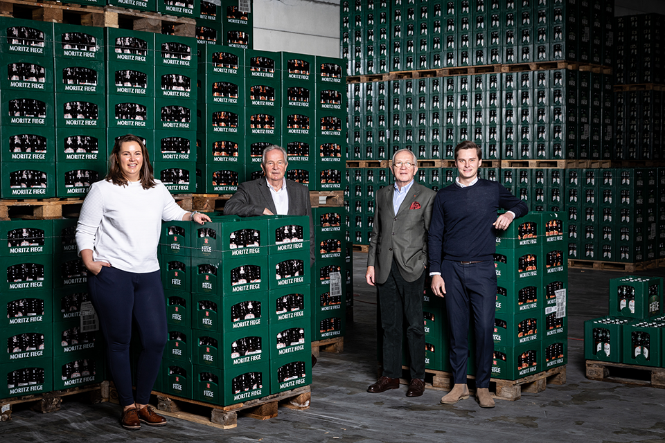 Das Team der Brauerei Moritz Fiege im Lagerraum mit Bierkisten. (Foto: Moritz Fiege)