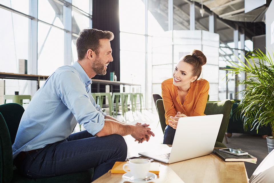 Ein Mann und eine Frau sitzen zusammen mit einem Laptop und besprechen Geschäftliches. Foto: baranq/Shutterstock.com