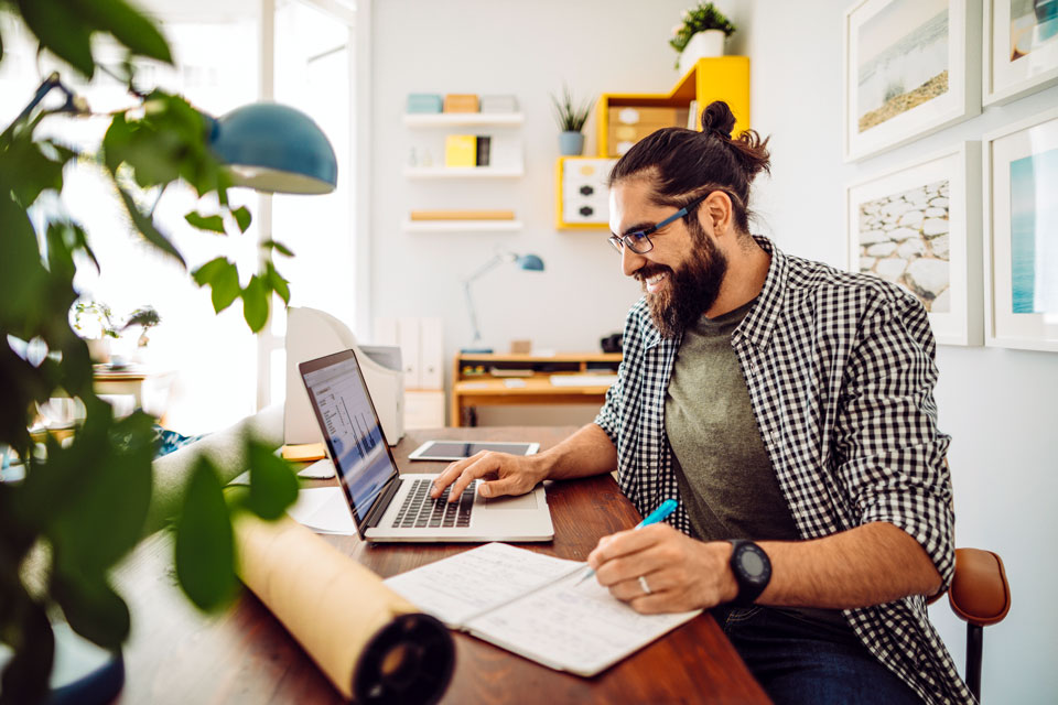 Mann mit Laptop am Wohnzimmertisch (Foto: Eva-Katalin/iStock)