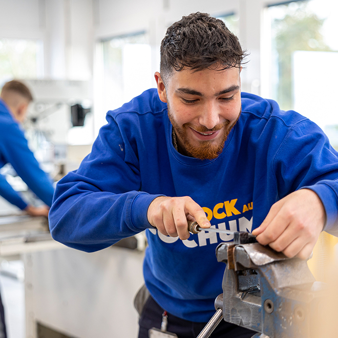 Junger Mann bei handwerklicher Arbeit an Werkbank