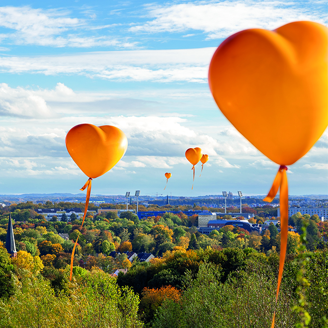 Bürgerprojekte Stadtwerke Bochum - orange Luftballonherzen am Himmel