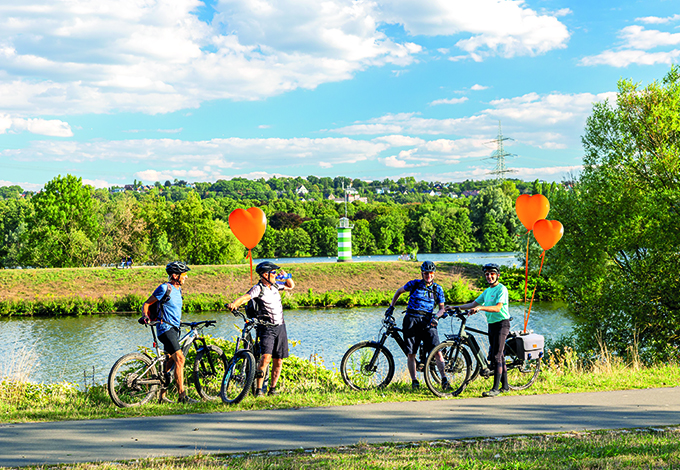 Bürgerprojekte Stadtwerke Bochum - Radfahrer mit Luftballonherzen machen Station am Kemnader Stausee