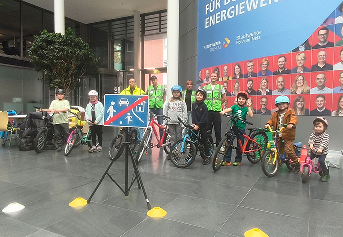 Kinder mit Fahrrädern und Begleiter in Sicherheitswesten in Bochum