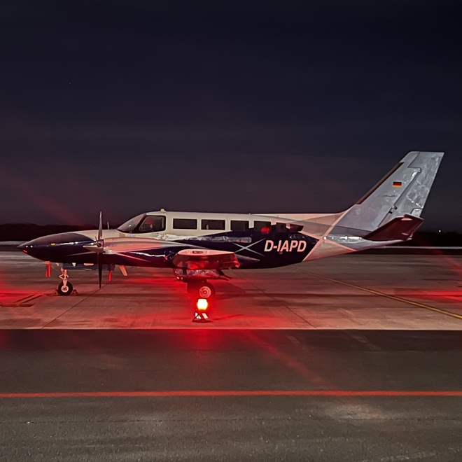 Kleines Flugzeug auf Rollfeld bei Nacht