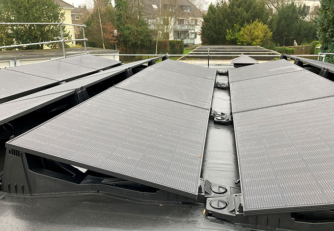 Solarmodule auf dem Dach mit Wohnhäusern im Hintergrund