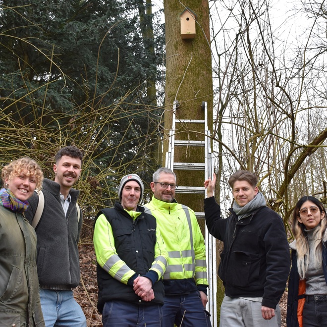 Sechs Personen vor Baum mit Nistkasten in Bochum