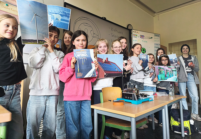 Schüler zeigen Bilder zu erneuerbaren Energien im Klassenzimmer