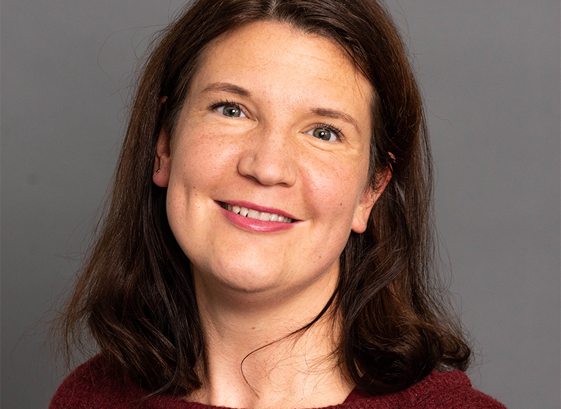 Porträt einer lächelnden Frau mit braunen Haaren.