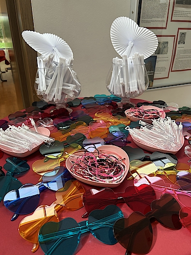 Bunte Herz-Sonnenbrillen und weiße Fächer auf Tisch