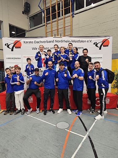Gruppe jubelnder Karateka vor Banner des Karate Dachverbands NRW