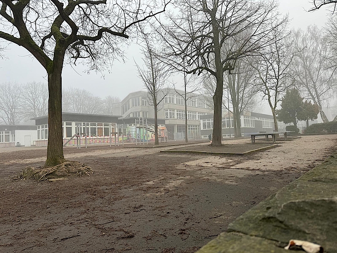 Spielplatz und Gebäude bei Nebel in Bochum