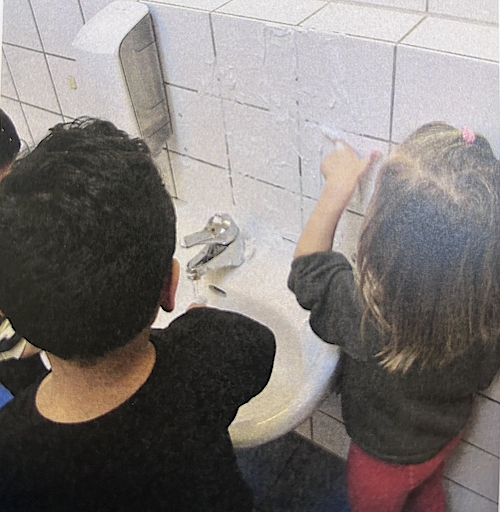 Kinder waschen ihre Hände an einem Waschbecken