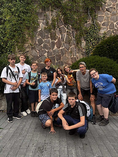 Gruppenfoto von Jugendlichen und einem Erwachsenen vor einer Steinwand