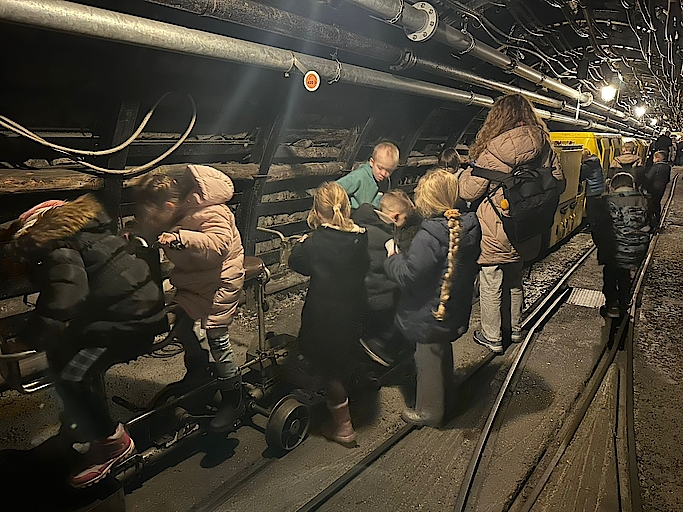Kinder in einem Bergwerkstunnel auf Förderwagen