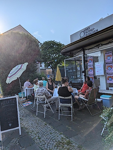 Menschen sitzen draußen vor dem Schaubüdchen in Bochum.