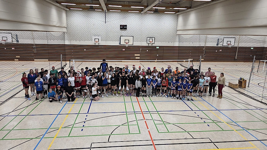Gruppenfoto vieler Volleyballspieler in Sporthalle