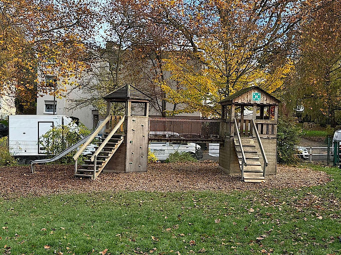 Holz-Klettergerüst auf einem Spielplatz mit Herbstlaub