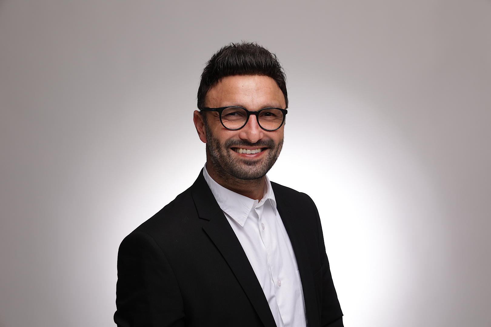 Porträt eines lächelnden Mannes mit Brille in Geschäftskleidung