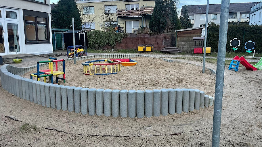 Spielplatz mit Sandkasten und bunten Spielgeräten in Bochum