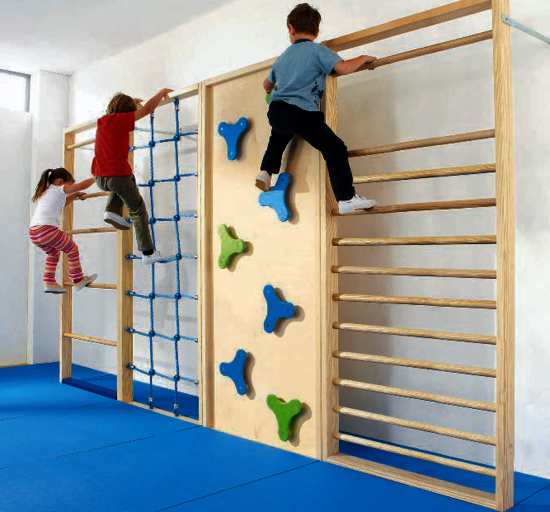 Kinder klettern an einer Kletterwand in einem Raum