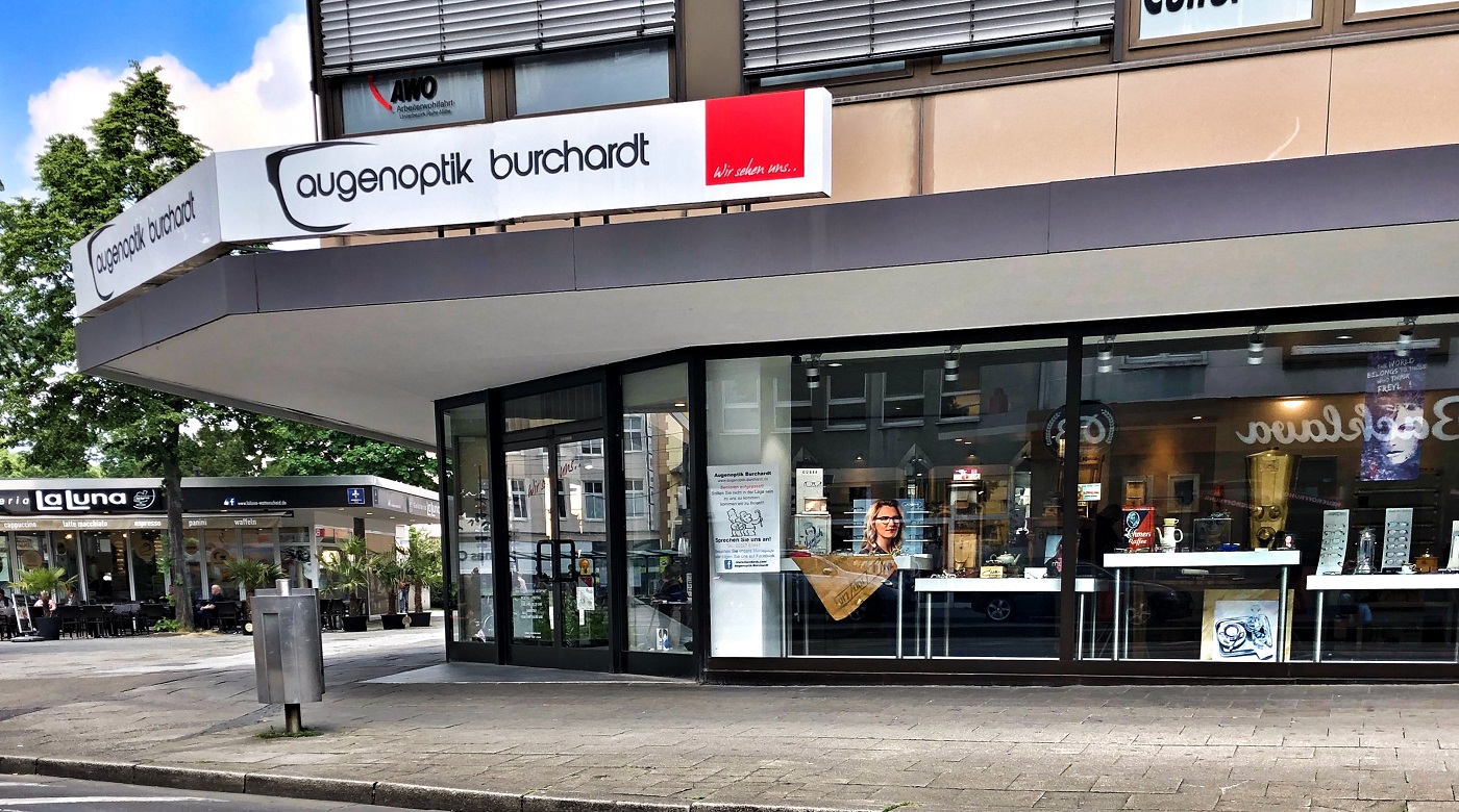 Außenansicht von Augenoptik Burchardt mit Schaufenster und Firmenschild an der Ecke.