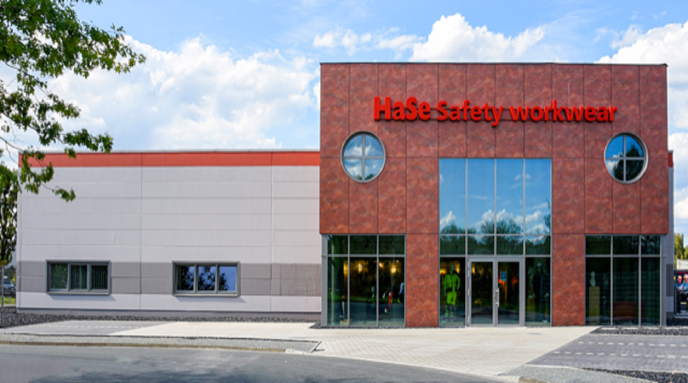 Modernes Gebäude von HaSe Safety Workwear mit Glasfront und rotem Schriftzug.