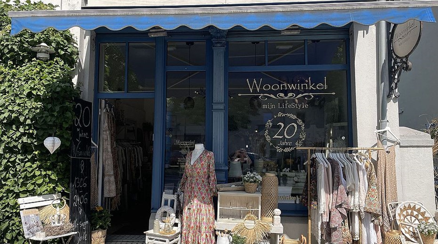 Eingang des Woonwinkel mit blauer Markise, Dekorationen und Kleidung im Vintage-Stil.